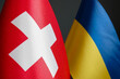 Nearby are small flags of Switzerland and Ukraine.