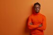 Portrait of a confused puzzled minded African American man in orange top isolated on blue background, with copy space.