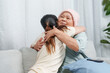© Ekkasit A Siam - Embrace exchanged between senior in rosy headwear and younger woman, symbolizing familial love. Affectionate hug captured amidst elder with blush beanie, and younger counterpart, sharing happiness.