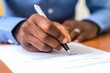 © Iftikhar alam - A man seated at a desk, using a pen to write on a sheet of paper, A hand signing a business loan agreement, AI Generated