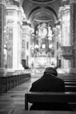Fototapeta Tęcza - Older gentleman sitting in the church. Black and white photo. Selective focus.