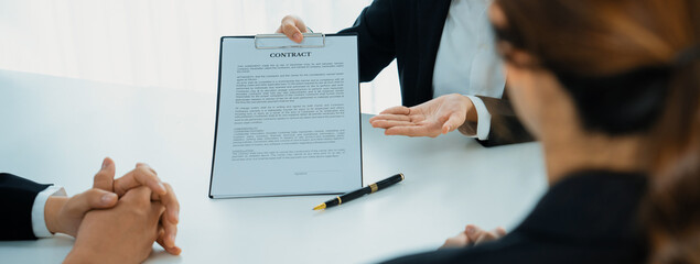 Wall Mural - Business executive signing contract agreement document on the bale with the help from company attorney or lawyer service in law firm office. Business investing and finalizing legal processing. Shrewd