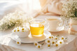 A warm cup of chamomile tea offers relaxation and comfort on a summer morning, its floral aroma and delicate flavor soothing the senses and promoting well-being.