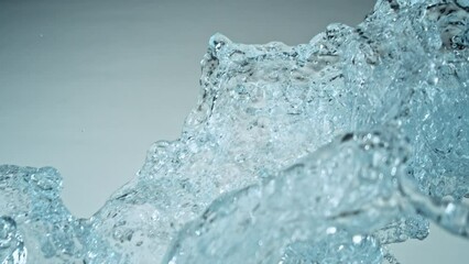 Wall Mural - Super Slow Motion of Flying Water Splashes, Isolated on Blue Background. Filmed on High Speed Cinema Camera, 1000fps. Speed Ramp Effect.