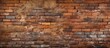 A detailed close up of a vintage brown brick wall showcasing the intricate brickwork pattern. The aging building material adds art to the composite structure