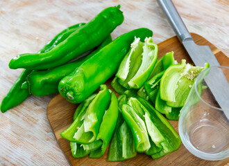 Wall Mural - Sweet green bell pepper sliced on wooden cutting board, prepared for cooking