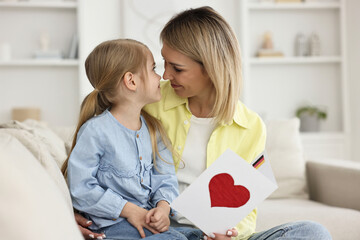 Sticker - Little daughter congratulating her mom with greeting card at home. Happy Mother's Day