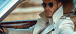 Confident stylish male model in white trench coat and sunglasses sitting in a luxury car