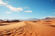 Sandy desert with towering mountains under a clear blue sky