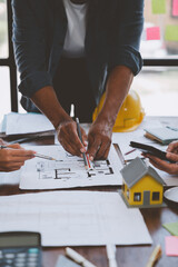 Wall Mural - Team of engineers reviewing blueprints Sketch of a new construction project with engineering tools at office desk. For improvement of house designs in mortgage, rent, sale, real estate