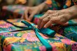 Detailed view of hands wrapping presents with colorful paper and ribbons, showcasing artistic and careful process