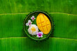 Thai dessert - mango sticky rice on banana leaf plate puts on banana leaf background.