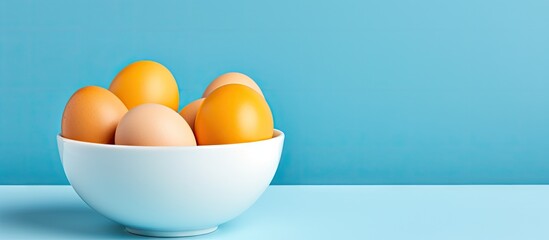 Sticker - Eggs in a white bowl on a sky blue background