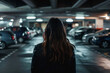 Back view of woman alone in dark parking garage