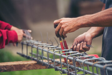 Construction Men hands bending cutting steel wire fences bar reinforcement of concrete work. Worker hands using pincer pliers iron wire. Outdoor Worker using wire bending pliers, construction work