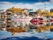 Colorful fishing boats in Stykkisholmur port reflected in the calm waters of North Atlantic Ocean. Calm morning scene of west Iceland, Europe. Traveling concept background.
