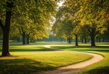 Fototapeta Londyn - Morning in the park with green grass, trees and sunbeams