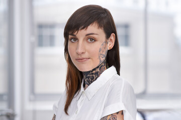 Business, woman and tattoo with portrait in office with confident attitude, serious and pride with mockup space. Entrepreneur, face of artist and designer with ink skin, body art and grunge aesthetic