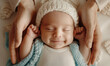 Smiling newborn baby sleeping in mother's hands.