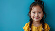 Little girl smiling on a blue background, back to school banner