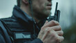 Close-up of a security guard using a walkie-talkie, focus on professionalism.