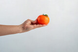 Fototapeta  - Orange fruit in hand isolated on white background.