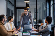 © Dusan Petkovic - A serious manager is standing at boardroom with his interracial team and having meeting about project.