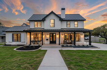 A Beautiful Two Story Modern Farmhouse Home With White Paint And Black Trim, Large Open Concept Living Room With A Dark Blue Grey Metal Roof,