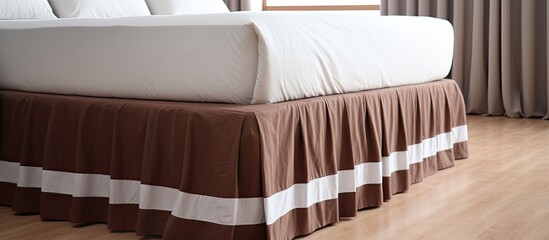 Poster - A wood bed with a brown and white bed skirt sits on rectangle hardwood flooring in a bedroom with metal building accents and patterned linens