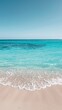 A sandy beach with crystal clear blue water stretching out to the horizon under a bright sunny sky. Waves gently lapping at the shore, creating a serene atmosphere.