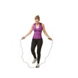 Fitness, skipping rope and woman on a white background for training, cardio workout and exercise. Sports, endurance and isolated person with gym equipment for health, wellness and jumping in studio