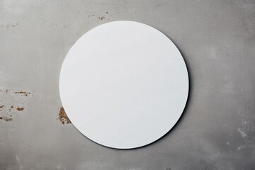 A mock-up of a round white sticker on a concrete background