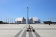 Bowl of Olympic flame Firebird and singing Fountain in Olympic park. Symbol of Olympic Games of 2014 in Sochi, woman on moped