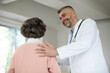 © Home-stock - Cheerful male doctor touching elderly female patient shoulder, expressing empathy and care, successful treatment or medical checkup result