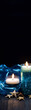 Two burning candles on a dark blue background with a blue cloth and starfish