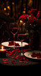 Still life photography of two wine glasses, a vase of red roses, and a candle on a table scattered with rose petals.