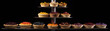 An assortment of pies with various colorful fruit toppings arranged on a metal shelf against a black background.