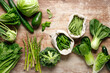 Vegetables background. Various green vegetables on kitchen table. Clean eating, healthy food concept, flat lay, top down view