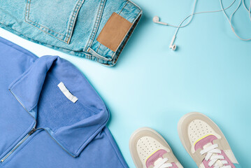 Wall Mural - Outfit for teenagers on a blue background. Casual street style, top view point, flat lay.