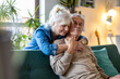 © pikselstock - Portrait of a happy senior couple sitting on sofa at home