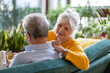 © pikselstock - Portrait of a happy senior couple sitting on sofa at home