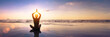 © NicoElNino - Wellbeing and mindfulness through yoga practice. Silhouette of a fit woman yogi in lotus pose on a calm beach at sunset. Harmony, balance, serenity and spirituality in meditation. Healthy lifestyle.
