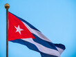 CUBA flag waving with a cloudy blue sky. Large flag in the heart of Cuba, Havana. Cuban flag - main symbol of Havana, Cuba. Cuba Flag Waving on flagpole, close up. Cuba flag flaping in wind. Close-up 