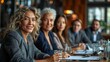 © jul14ka - Senior female ceo and multicultural business people discussing company presentation at boardroom table