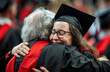 Emotional moment of a female graduate hugging an elder during commencement with visible joy and pride