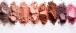 A row of smashed eye shadows in various colors resembling a rocky terrain on a blank canvas. An artistic recipe for creating glutenfree makeup art