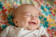 © Татьяна Евдокимова - Close-up of a cheerful infant with a beaming smile, lying on a vibrant patterned textile