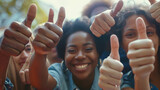 Fototapeta  - Close up of group of diverse people showing raised thumbs at camera as gesture of recommendation or good choice. Professional multicultural team demonstrates satisfaction and gives a positive response
