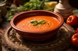 Juicy gazpacho in a clay dish against a natural brick background
