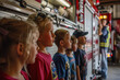 Children line up eagerly watching a firefighter at work, captivated by the scene.